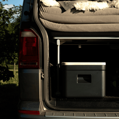 Rear view of a van with an open trunk, showcasing the compact Trelino Origin S composting toilet inside, highlighting its space-saving design for van life and travel.