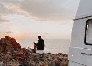man sitting on Trelino Origin S toilet by ocean