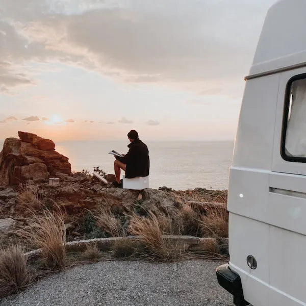 Man sitting on Trelino toilet by ocean