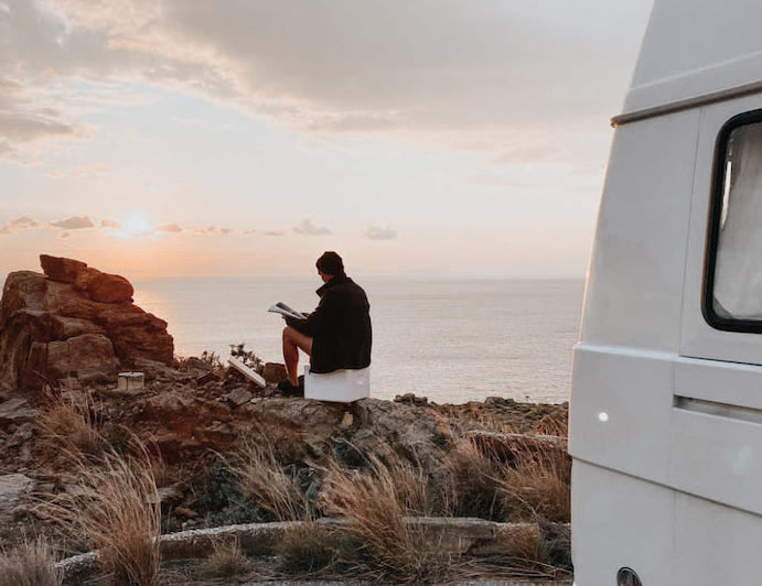 person sitting on Trelino Origin S toilet by the ocean