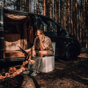 Man sitting on an Evo L composting toilet in front of his van.