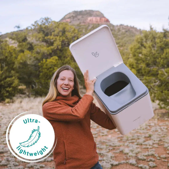 Medium lightweight camping toilet being held by camper