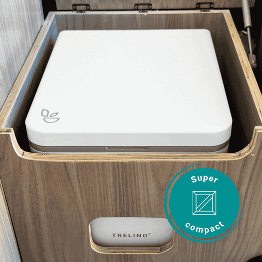 A compact white TRELINO composting toilet shown inside a wooden drawer with a teal circular badge reading 'Super compact' overlaid on the lower right.