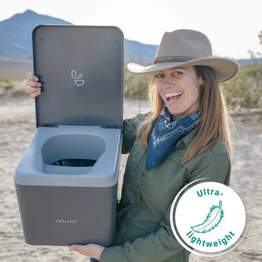 Small lightweight camping toilet being held by camper