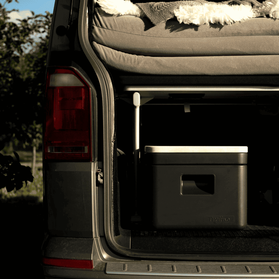 Rear view of a van with an open trunk, showcasing the compact Trelino Origin S composting toilet inside.