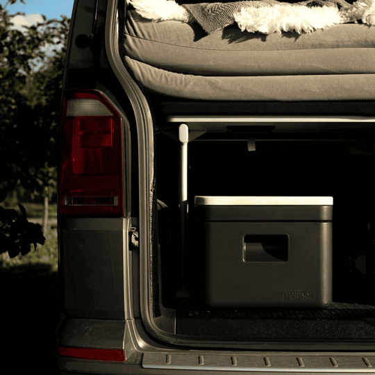 Rear view of a van with an open trunk, showcasing the compact Trelino Origin S composting toilet inside.